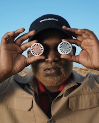 a black man is holding two discs in front of his eyes