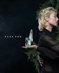 a woman holding a bottle with the words peak pro on it