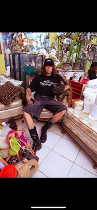 a man sitting on a couch in a room full of stuffed animals
